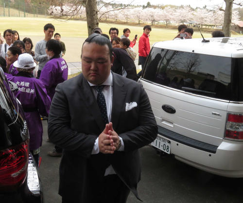 地元茨城県で行われた巡業であいさつ後、桜を背に警備担当者に感謝して手を合わせながら引き揚げる荒磯親方