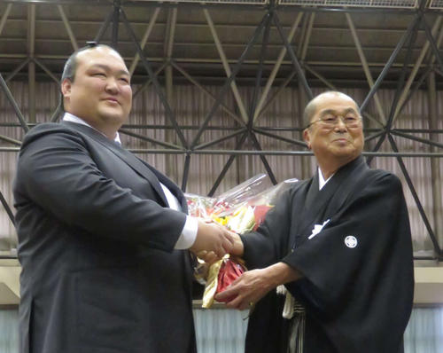 地元茨城県で行われた巡業で、常陸大宮市の三次市長（右）から花束を受け取った荒磯親方