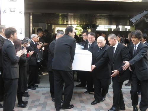 関係者によって出棺される墨谷さんの棺