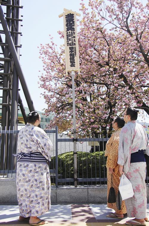 「令和元年」と記された大相撲夏場所の御免札を見上げる力士たち（共同）