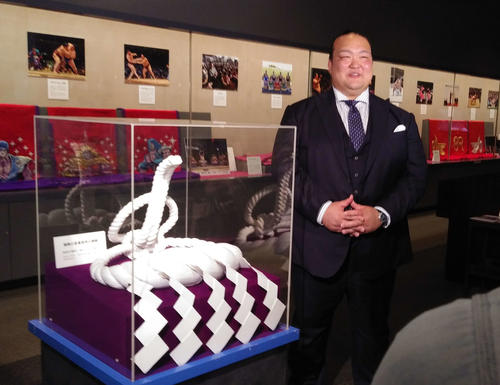 特別展「七十二代横綱　稀勢の里」の内覧会で、展示品を解説しながら笑顔を見せる荒磯親方