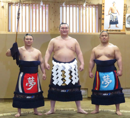 新たに完成した綱を締め、土俵入りを務める予定の炎鵬（左）、石浦（右）と記念撮影に納まる白鵬