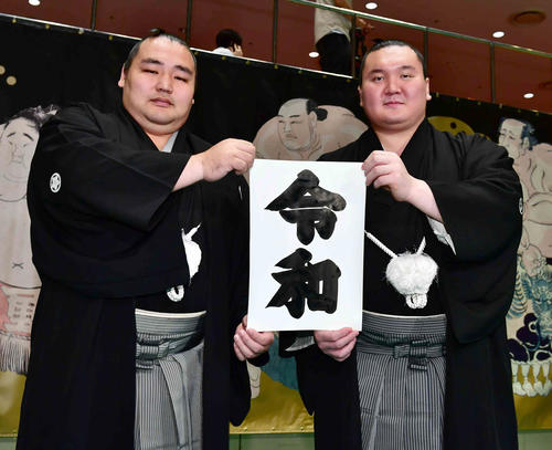 「令和」と筆書きされた書物を手にする鶴竜（左）と白鵬（撮影・小沢裕）