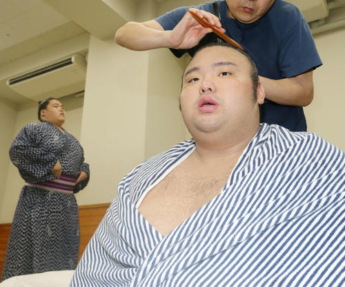 取組後、支度部屋で記者の質問に答える貴景勝（右）。後方左は納谷（撮影・河田真司）