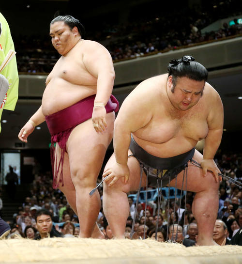 御嶽海（左）を寄り切ったが、膝を押さえ苦しい表情の貴景勝（撮影・河田真司）