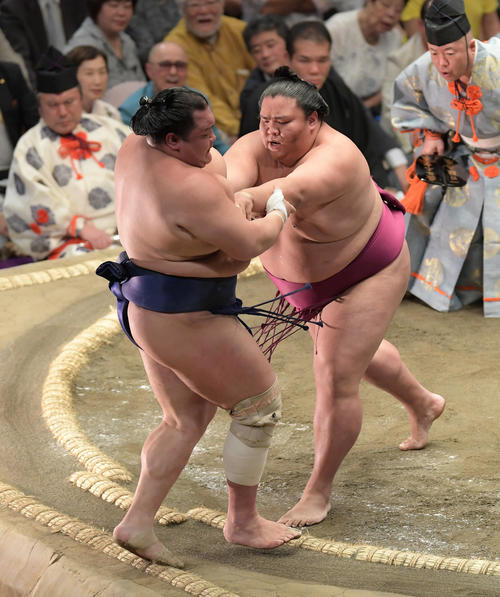 御嶽海(右)は押し出しで北勝富士を下す(撮影・加藤諒)