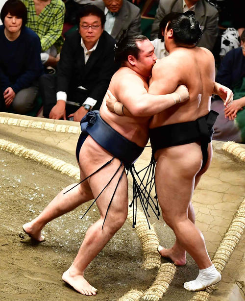 鶴竜（左）は隠岐の海を寄り切りで下す（撮影・小沢裕）