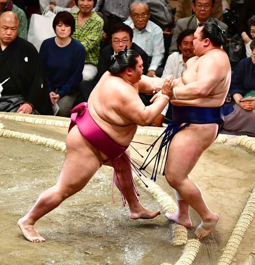 御嶽海（左）は押し出しで北勝富士を下す（撮影・小沢裕）