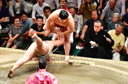 阿炎は明生（左）をはたき込みで下す。右は勝負審判の阿武松審判部長（撮影・小沢裕）