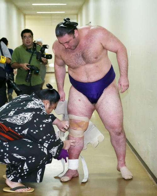 インタビュールームへ向かう途中、右足のサポーターを外してもらう栃ノ心（撮影・河田真司）
