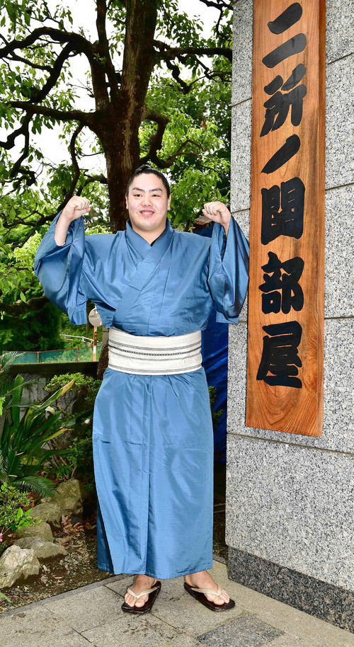 来場所での十両昇進が決まった一山本は二所ノ関部屋の看板の前でガッツポーズ（撮影・小沢裕）　