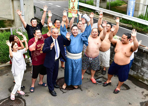 来場所での十両昇進が決まった一山本（中央）は師匠の二所ノ関親方（中央左）、高田みづえ夫人ら二所ノ関部屋の仲間たちから万歳の祝福を受ける（撮影・小沢裕）　