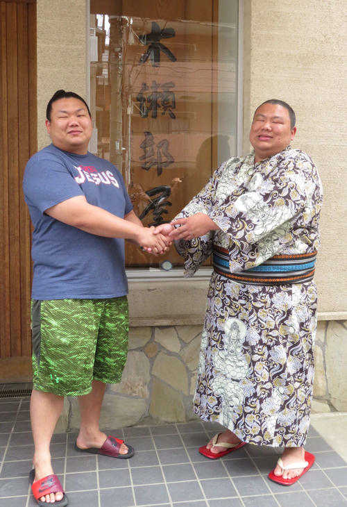 新十両に昇進した木崎海（右）は笑顔で兄の美ノ海と握手を交わした