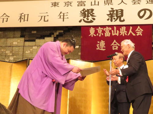富山県人会に出席し、表彰状を受け取った朝乃山（左）。中央は富山県の石井知事、右は東京富山県人会連合会の桑山会長