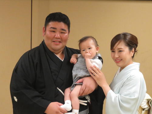 断髪式後、整髪を終え長男維風輝君を抱く秀ノ山親方（左）と亜香利夫人