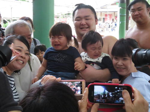 茨城合宿初日の稽古後、抱っこした2人の子どもに泣かれ、苦笑いしながら撮影に応じる朝乃山