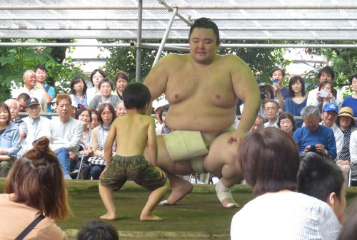 多くの市民が見つめる中、茨城合宿初日の稽古後、地元の子どもと相撲を取る朝乃山