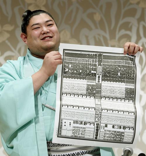 大相撲名古屋場所の番付表を手に笑顔を見せる新小結の阿炎（共同）