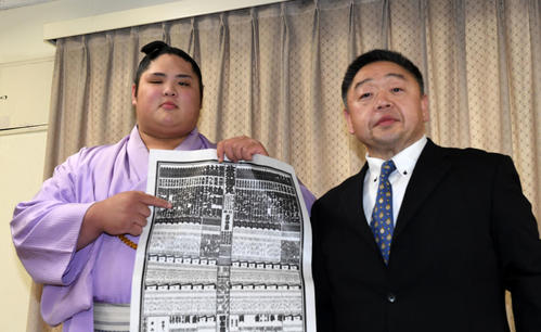 千賀ノ浦親方（右）と会見する新入幕の貴源治は番付の名前を指さす（撮影・前岡正明）