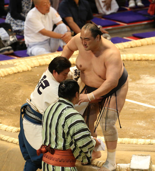 右膝を痛めて抱えられて土俵を下りる安美錦（右）（撮影・白石智彦）