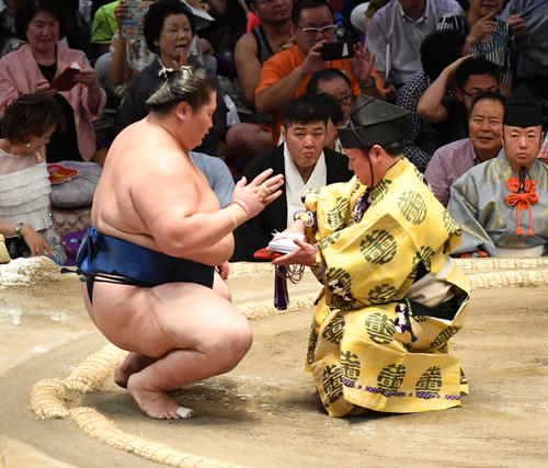 白鵬を破り勝ち名乗りを受け懸賞金の束を手にする逸ノ城（撮影・前岡正明）