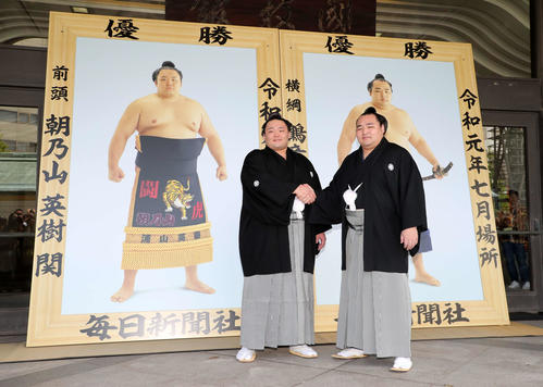 優勝額の前で握手する朝乃山（左）と鶴竜（撮影・鈴木正人）