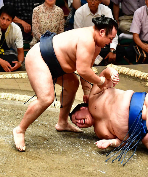 11日、鶴竜（左）に肩すかしで敗れた逸ノ城は右肩を痛め苦悶（くもん）の表情を見せる（撮影・小沢裕）