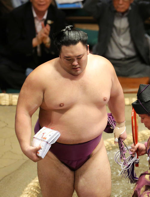 鶴竜を破り、懸賞金の束を手に土俵から引き揚げる朝乃山（撮影・河田真司）