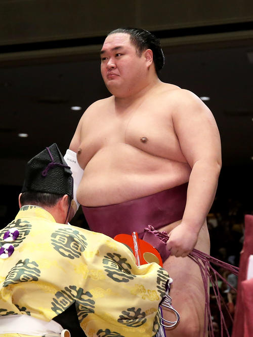 鶴竜を破り懸賞金の束を手にする友風は、目に涙を浮かべる（撮影・河田真司）