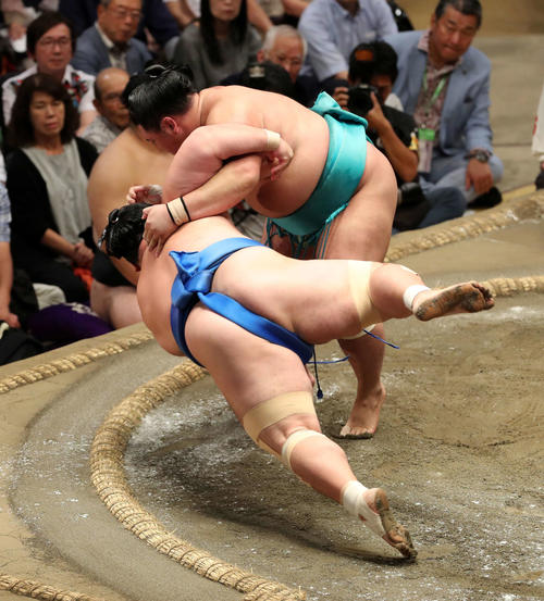琴奨菊（手前）をすくい投げで破る明生（撮影・鈴木正人）