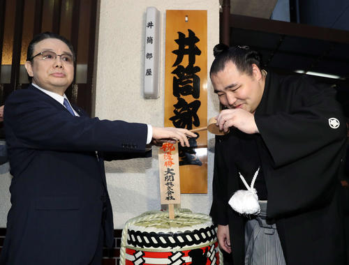 優勝した鶴竜に水を付ける井筒親方（2018年5月27日撮影）