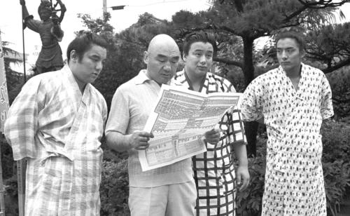 81年7月、名古屋場所の番付を見つめる井筒親方と三兄弟。左から長男の鶴嶺山、井筒親方、福薗（後の逆鉾）、三男の寺尾
