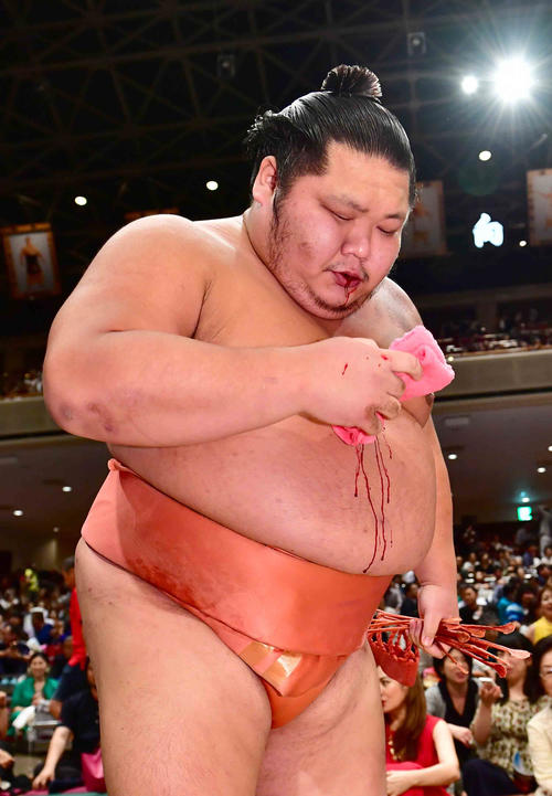 流血した唇をタオルで押さえながら引き揚げる千代大龍（撮影・小沢裕）