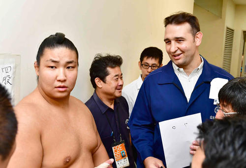 三段目優勝を決めた佐田ノ輝（左）は鳴戸広報担当から身長体重など詳細の確認を受ける（撮影・小沢裕）
