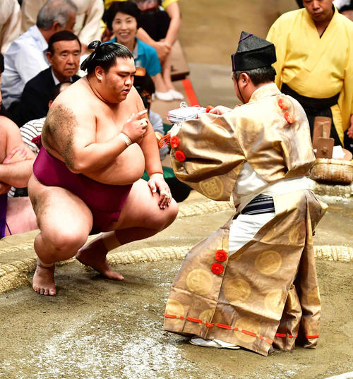 3敗を死守し懸賞を受け取る御嶽海（撮影・小沢裕）