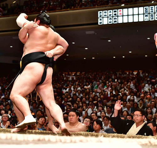 隠岐の海（手前）は遠藤を土俵際へ攻め込む。右は遠藤の足が出たと手を挙げる審判の竹縄親方（撮影・小沢裕）