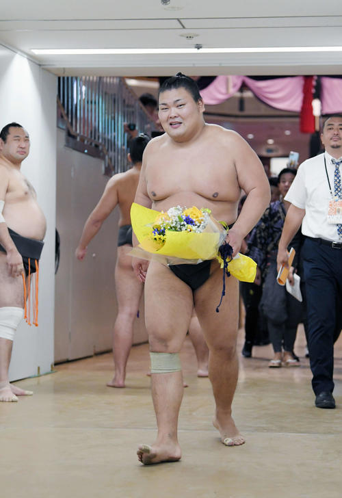 現役最後の取組を終え、花束を手に花道を歩く大喜鵬（撮影・加藤諒）