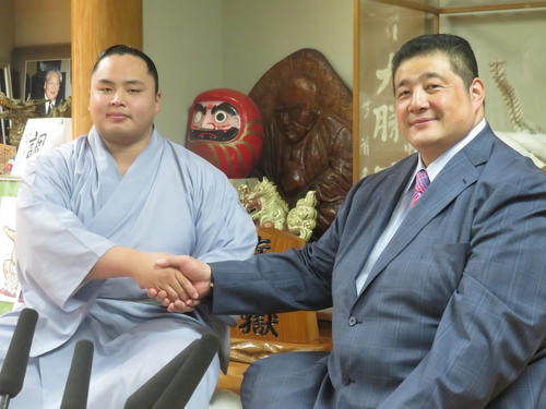 新十両昇進会見で佐渡ケ嶽親方（右）と握手をかわす琴手計改め琴勝峰