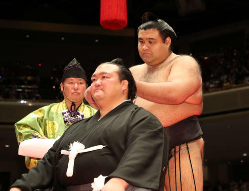 元横綱稀勢の里の荒磯親方にはさみを入れる高安（撮影・鈴木正人）