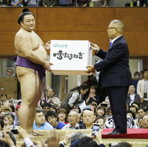 地元富山で行われた秋巡業で勧進元からたまねぎ100キロを贈呈された朝乃山（左）（撮影・佐藤礼征）