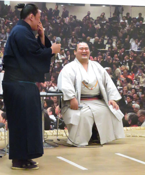 トークショーの壇上に招いた付け人の琴真鍋（左）の困惑気味な様子に笑顔を見せる琴奨菊