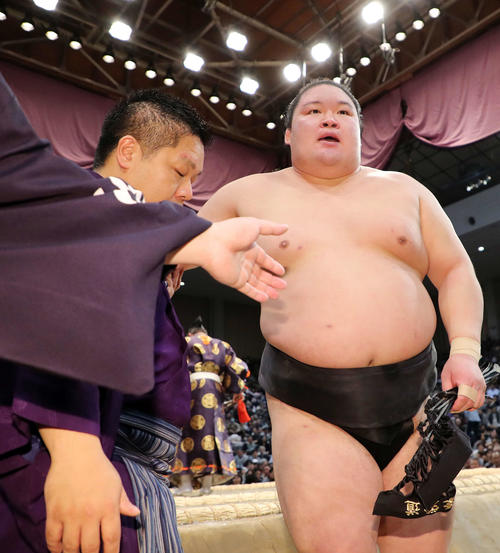 呼び出しの肩を借りて土俵を引き揚げる豪栄道（撮影・鈴木正人）