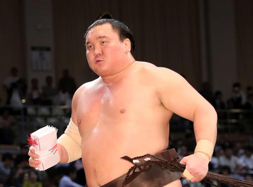 懸賞金の束を手に土俵を引き揚げる白鵬（撮影・鈴木正人）