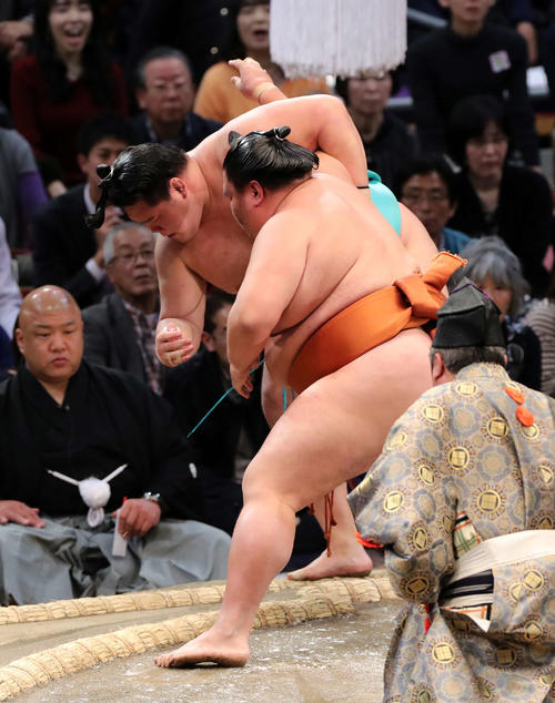 明生(後方)を寄り切りで破る御嶽海(撮影・鈴木正人)