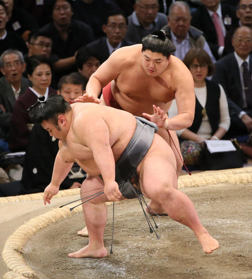 貴景勝（手前）を送り出しで破る阿炎（撮影・栗木一考）