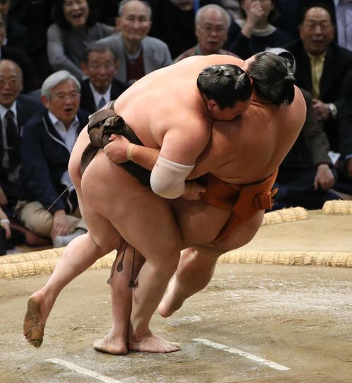 御嶽海（右）を外掛けで下す白鵬（撮影・栗木一考）