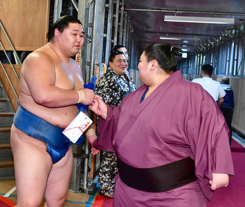 2ケタ白星を挙げた正代（左）は付け人とグータッチ（撮影・小沢裕）