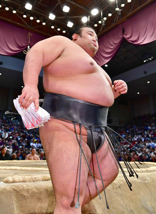 懸賞の束を手に土俵を下りる貴景勝（撮影・小沢裕）