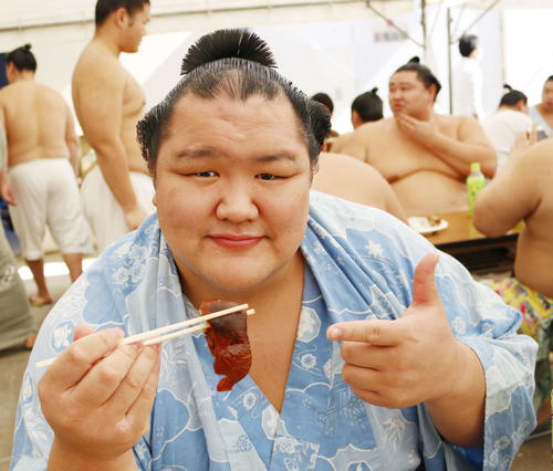沖縄・うるま市で行われた冬巡業で、沖縄料理のてびちを食べる北勝富士（撮影・佐藤礼征）
