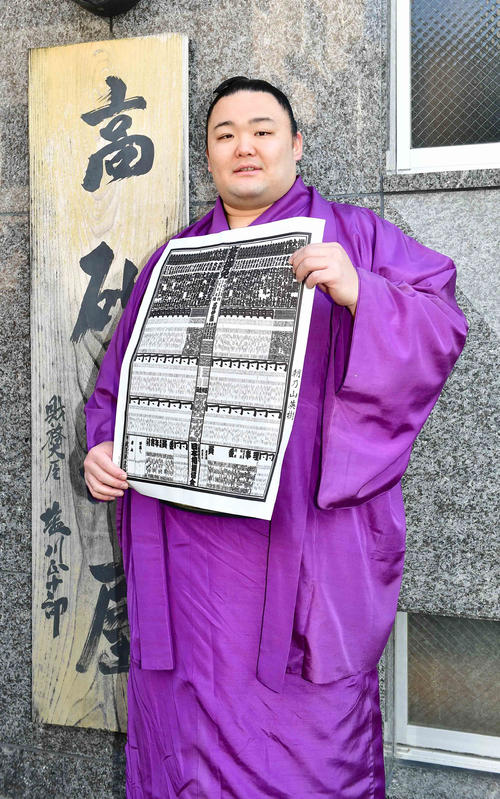 大相撲初場所から関脇に昇進し部屋の看板の前で番付を手に笑顔を見せる朝乃山（撮影・小沢裕）